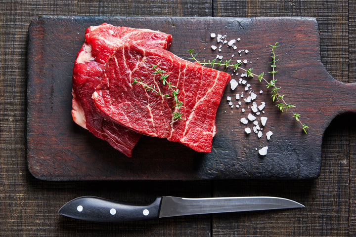 2 juicy flat iron steaks with thyme and salt on the side