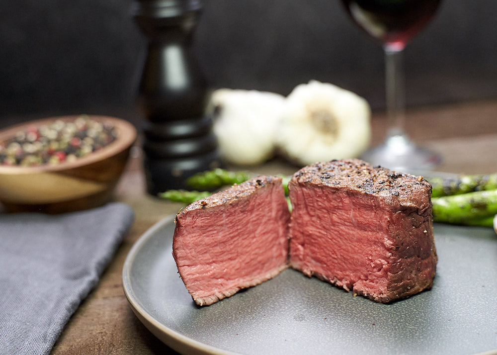 Filet mignon cooked over medium high heat, sliced open to show medium-rare colouring