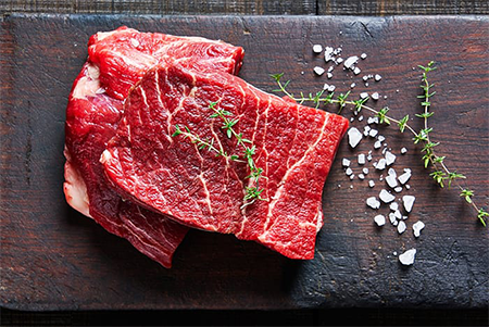 2 juicy flat iron steaks with thyme and salt on the side