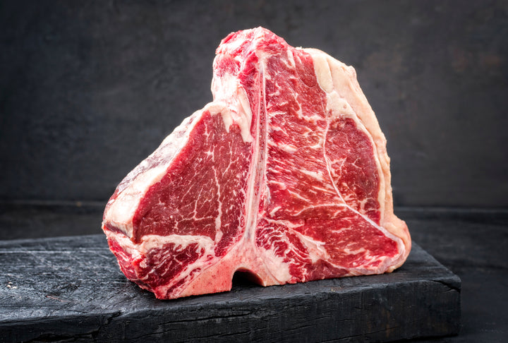 Massive Porterhouse with exquisite marbling standing upright on the bone